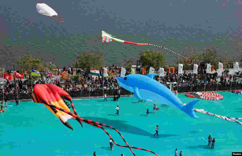 Kite enthusiasts fly kites during the International Kite Festival in Ahmedabad, India.