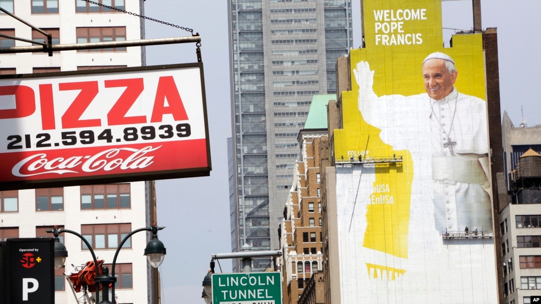 FILE - Sign painters work on a portrait of Pope Francis, right, on the side of a New York City building. The pope visits the U.S. beginning Sept. 22, with stops in Washington D.C., New York and Philadelphia. 