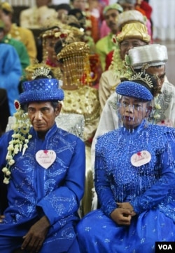 Indonesian couples wait for their turn to wed during a mass wedding ceremony in Jakarta, Indonesia, Wednesday, May 18, 2005. The mass marriage of the 47 couples was held by the State Secretariate to help the poor who were unable to afford proper wedding. (AP Photo/Dita Alangkara)