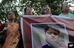 FILE - Bangladeshi social activists hold a banner displaying a portrait of blogger and author Ananta Bijoy Das during a protest against his killing, in Dhaka, Bangladesh, May 12, 2015.