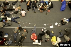 People sleep on the floor as they line up for the opening of a new Apple Store in Hangzhou, Zhejiang province, China, April 24, 2015.