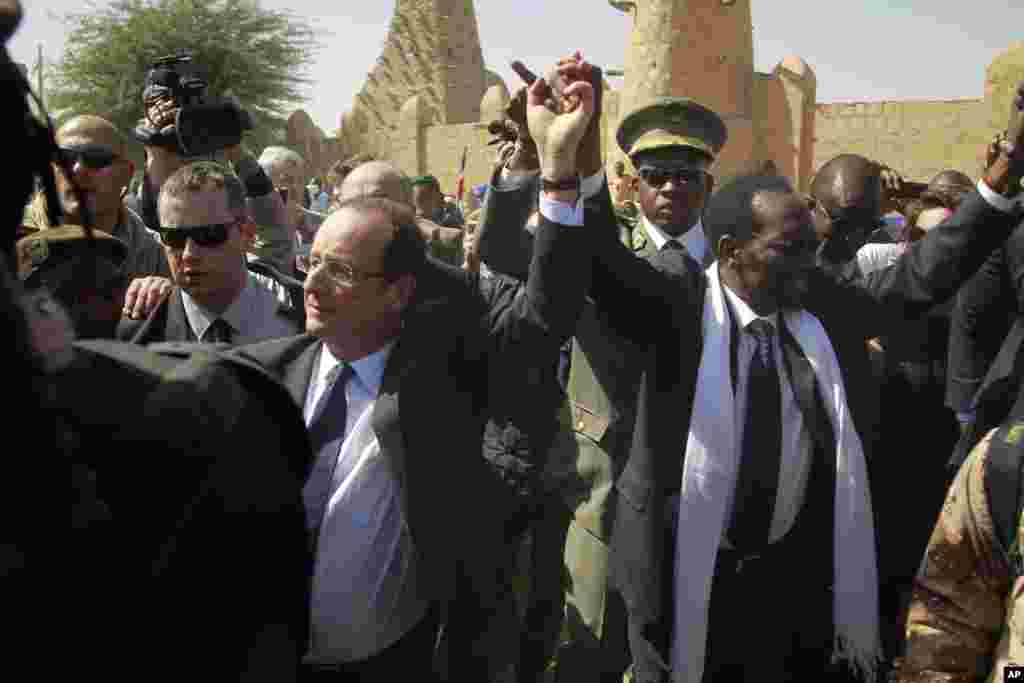 French President Francois Hollande holds hands with Mali's interim President Dioncounda Traoré in Timbuktu, Mali, February 2, 2013.