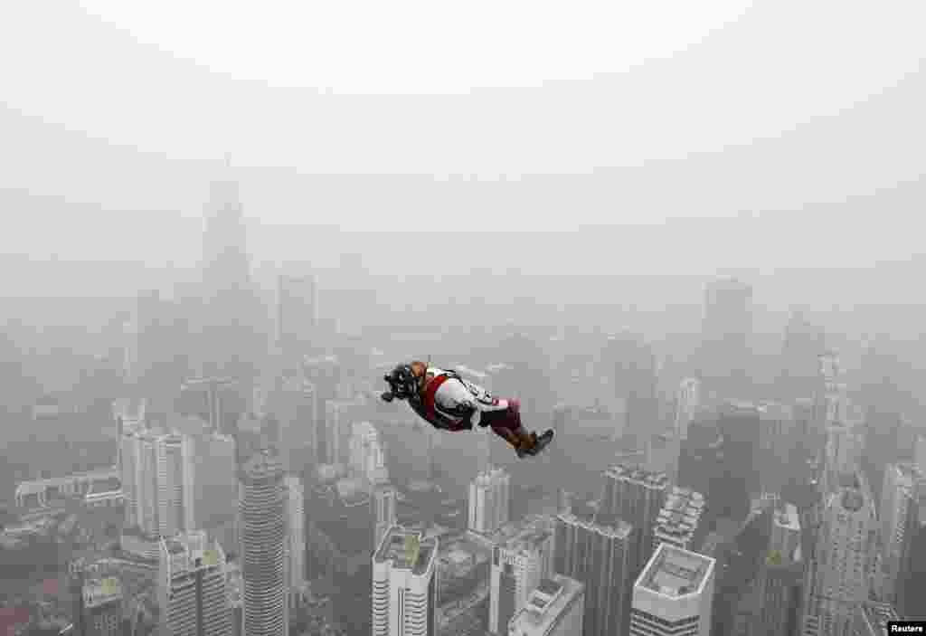 A BASE jumper leaps from the 300-meter-high Kuala Lumpur Tower during the International Tower Jump in which more than 100 people took part, on a hazy day in Kuala Lumpur, Malaysia.