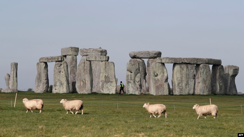 Sheep graze as security guards patrol the prehistoric monument at Stonehenge in southern England, on April 26, 2020, closed during the national lockdown due to the novel coronavirus COVID-19 pandemic. (Adrian DENNIS / AFP)