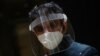 ຜູ້ຊາຍຄົນນຶ່ງໃສ່ແຜ່ນໃສປ້ອງກັນໂຄວິດ-19 ແລະໜ້າກາກປິດປາກ ຢູ່ໃນນະຄອນລອນດອນໃນະຂະນະທີ່ພະຍາດໂຄວິດ-19 ສືບຕໍ່ໄປ (ວັນທີ 13 ເມສາ, 2020) 