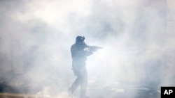 A police officer moves through tear gas deployed to disperse protesters in Philadelphia, Pennsylvania, May 31, 2020. 