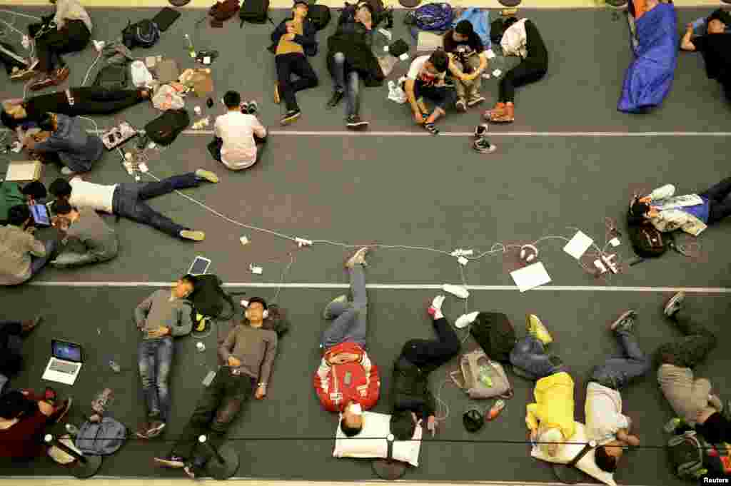 People sleep on the floor as they line up for the opening of a new Apple Store in Hangzhou, Zhejiang province, China. The 19th Apple Store in mainland China and second one in the city opened on Friday.