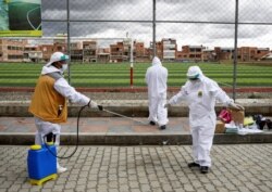 Un trabajador de salud desinfecta a un colega en un punto para pruebas rápidas de antígenos, en medio del brote de la enfermedad por coronavirus (COVID-19) en El Alto, Bolivia, 16 de enero de 2021.