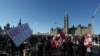 Para pendukung dari "Konvoi Kebebasan" yang memprotes mandat vaksin dan pembatasan terkait COVID-19 di Kanada, beraksi di depan gedung parlemen di Ottawa, Kanada, pada 29 Januari 2022. (Foto: AFP/Dave Chan)