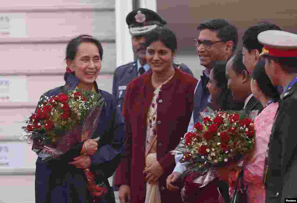 Myanmar's State Counsellor Aung San Suu Kyi (L) smiles after arriving at Air Force Station Palam in New Delhi, India, January 24, 2018. REUTERS/Adnan Abidi - RC1BBD3D1A60