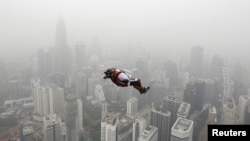 A BASE jumper leaps from the 300-metre high Kuala Lumpur Tower during the International Tower Jump in which more than 100 people take part, on a hazy day in Kuala Lumpur, Malaysia, Oct. 2, 2015. 