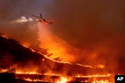 Air disemprotkan dari helikopter ke Kenneth Fire di wilayah West Hills, Los Angeles, Kamis, 9 Januari 2025. (Foto: AP)