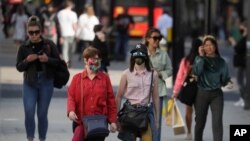 Pejalan kaki di Oxford Street, London, Inggris, mengenakan masker di tengah pandemi Covid-19, 21 September 2020. (Foto: dok).