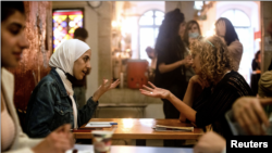 A Palestinian woman chats with an Israeli woman during a language exchange program modelled on speed dating, in Jerusalem, October 27, 2021. Picture taken October 27, 2021. REUTERS/Ronen Zvulun