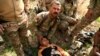 REUTERS Força de Intervenção Rápida iraquiana ajuda um rapaz ferido após ataque em Mosul, 24 Fev. 