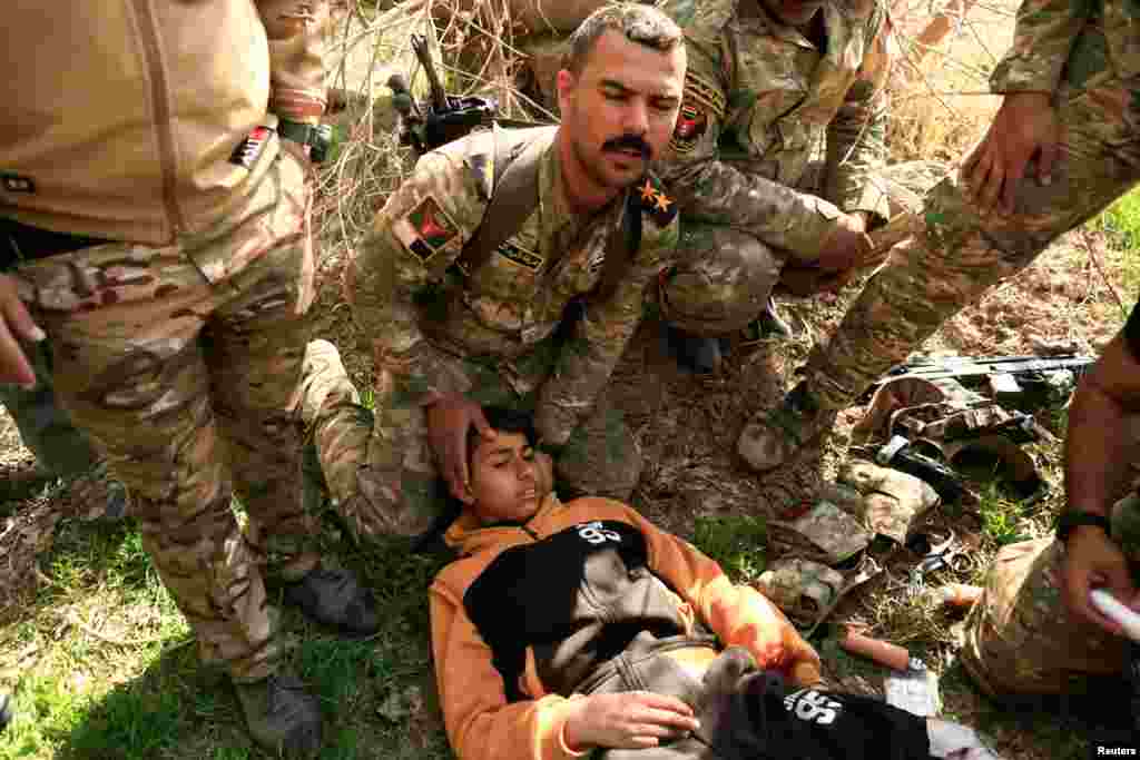 کمک سربازان عراقی به پسری که در نبرد بین داعش و ارتش عراق مجروح شده است. موصل، عراق.
