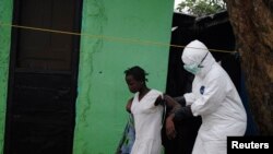 Wani ma'aikacin kiwon lafiya yake kawo wata mace da ake tuhuma ta kamu d a cutar Ebola