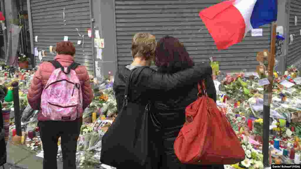 Mourners gather near Le Petit Cambodge and Le Carillon, which were the first restaurants hit in the multiple attacks across Paris Friday that left more than 120 people dead and hundreds wounded, Nov. 17, 2015.