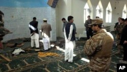 Polisi dan pejabat setempat memeriksa masjid Puli Alam di provinsi Logar, Afghanistan pasca ledakan bom (15/10). Bom yang disembunyikan di microfon mesjid tersebut meledak dan menewaskan Gubernur Afghanistan Arsallah Jamal saat menyampaikan kotbah Idul Adha.