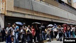 Rakyat Venezuela antri untuk membeli bahan dasar pangan di luar supermarket. Caracas, Venezuela