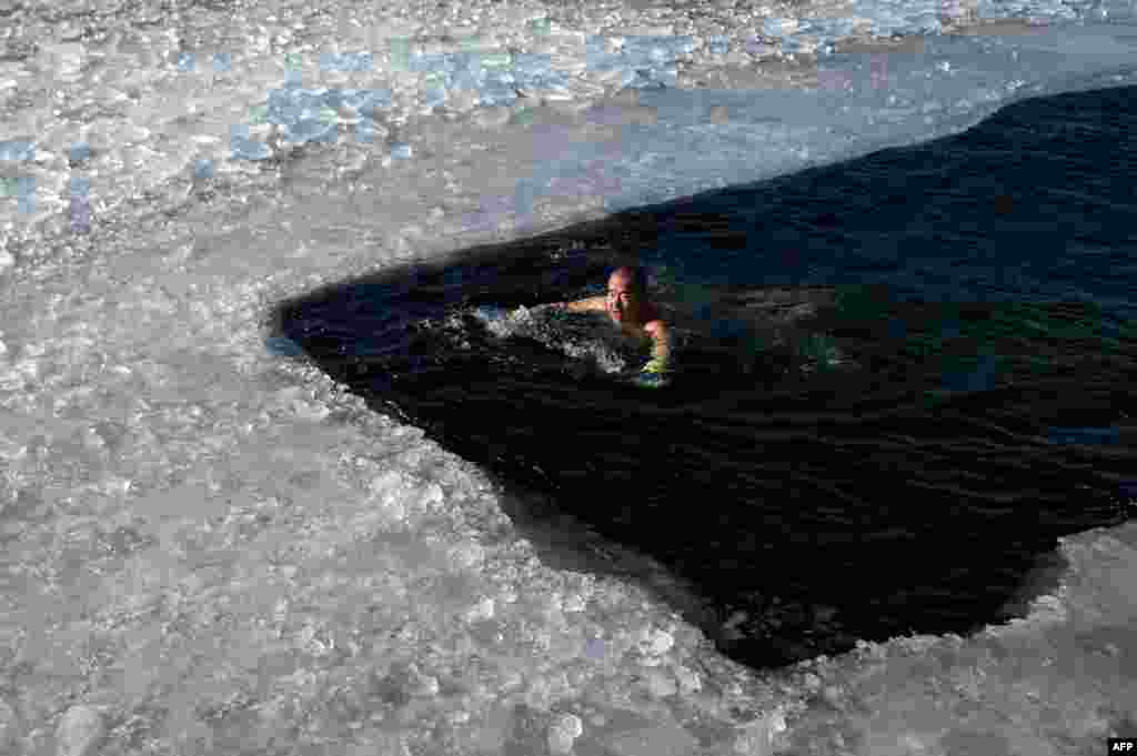 An ice swimmer swims in a frozen lake on a cold winter day in Beijing, China.