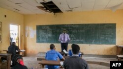 FILE - A teacher wearing a face shield teaches a class at the Technical High School of Nkol-Bisson in Yaoundé, Cameroon, June 1, 2020. 
