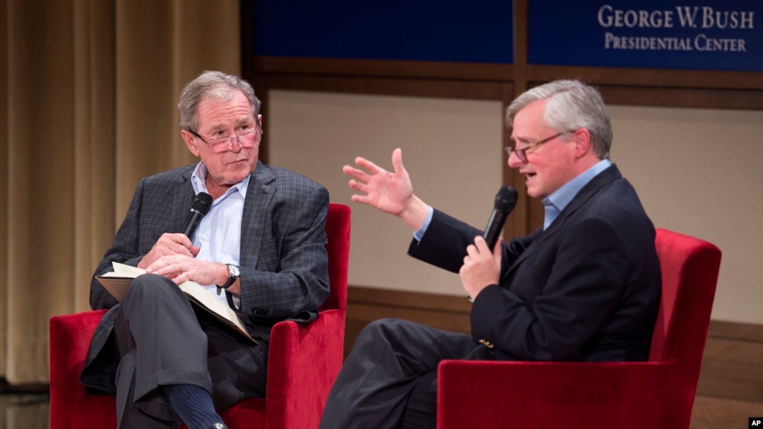 Former President George W. Bush, left, listens to Pulitzer Prize winning author Jon Meacham, right, talk about his biography of Bush's father, former President George H. W. Bush, Sunday, Nov. 8, 2015.