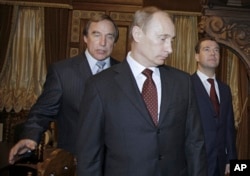 FILE - Russian cellist and House of Music Director Sergei Roldugin, left, escorts then Russian Prime Minister Vladimir Putin, center, and President Dmitry Medvedev as they tour a restored House of Music, a former palace of Great Prince Alexei Alexandrovich Pomanov, in St. Petersburg, Nov. 21, 2009.
