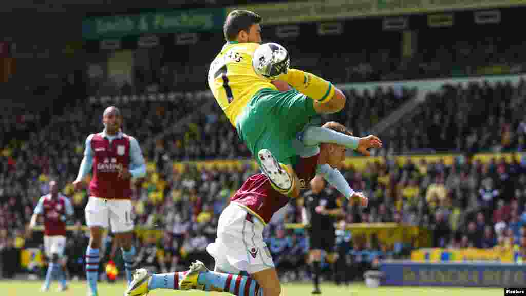 Norwich City's Robert Snodgrass (top) and Aston Villa's Joe Bennett jump for a cross during their English Premier League soccer match at Carrow Road in Norwich May 4, 2013.