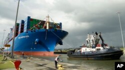 In this Dec. 3, 2018, photo, a Panama Canal worker docks the Chinese container ship Cosco at the Panama Canals' Cocoli Locks, in Panama City. (AP Photo/Arnulfo Franco)