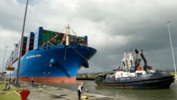 Pekerja di Kanal Panama mengaitkan kapal kontainer Cosco asal China saat kapal tersebut tiba di Kanal Panama pada 3 Desember 2018. (AP/Arnulfo Franco)