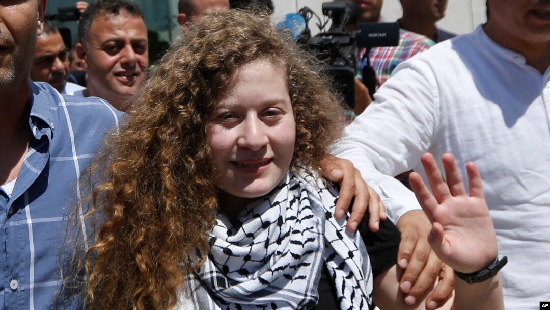Ahed Tamimi vẫy tay chào mọi người khi tới thăm mộ cố lãnh đạo Palestine Yasser Arafat ở thành phố Ramallah ở Bờ Tây hôm 29/7. Biểu tượng đấu tranh của Palestine, Ahed Tamimi, và mẹ cô trở về nhà ở một ngôi làng ở Bờ Tây trong sự chào đón của người dân làng đối với một anh hùng.