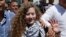 Ahed Tamimi vẫy tay chào mọi người khi tới thăm mộ cố lãnh đạo Palestine Yasser Arafat ở thành phố Ramallah ở Bờ Tây hôm 29/7. Biểu tượng đấu tranh của Palestine, Ahed Tamimi, và mẹ cô trở về nhà ở một ngôi làng ở Bờ Tây trong sự chào đón của người dân làng đối với một anh hùng.