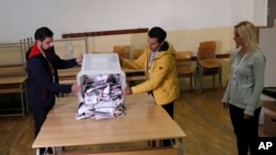 Members of an election commision count votes at a polling station in the northern Serb-dominated part of the ethnically divided town of Mitrovica, Kosovo, Oct. 6, 2019.