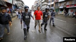 Nepalese police personnel detain a protester (C) during a general strike organized by the Nepal Federation of Indigenous Nationalities (NEFIN) demanding autonomous regions based on ethnicity to be drafted into the new constitution in Kathmandu, Nepal, Aug. 24, 2015.