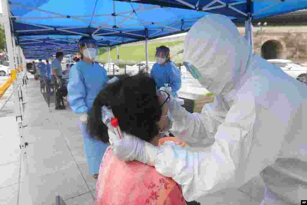 ماموران درمانی و بهداشتی در شهر سئول کره جنوبی در حال گرفتن نمونه برای آزمایش کرونا از بیماران. 