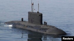 FILE - Iranian military personnel stand on a submarine during a naval parade on the last day of the Velayat-90 war game in the Sea of Oman near the Strait of Hormuz in southern Iran January 3, 2012.