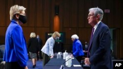 FILE - Sen. Elizabeth Warren, D-Mass., talks to Federal Reserve Chairman Jerome Powell before a Senate Banking, Housing and Urban Affairs Committee hearing on the CARES Act on Capitol Hill, Sept. 28, 2021.