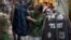 A woman checks a jacket for sale at an open market along a Hutong alley in Beijing, China, September 9, 2012. 