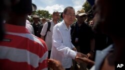 El secretario general de la ONU, Ban Ki-moon, saluda a haitianos a su llegada a Hinche, Haití.