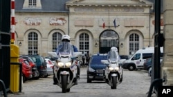 Policemen escort the vehicle transporting Mehdi Nemmouche, the Frenchman suspected in the shooting deaths of three people at the Brussels Jewish Museum, as he leaves the Appeals Court of Versailles, France, June 5, 2014.