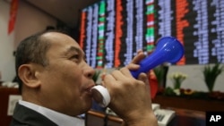 Pialang saham Filipino meniup terompet di Bursa Saham Makati, Manila, menjelang akhir tahun 2013. (Foto: Dok)