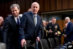 FILE - FBI Director Christopher Wray, left, and Director of National Intelligence Dan Coats, second from left, arrive for a hearing in Washington, Feb. 13, 2018.