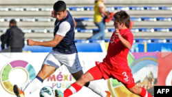 Mario Rodríguez (izquierda) de Estados Unidos disputa un balón con Marco Lapena de Canadá, en el partido ganado por los estadounidenses, que les valió la clasificación al Mundial sub-20.