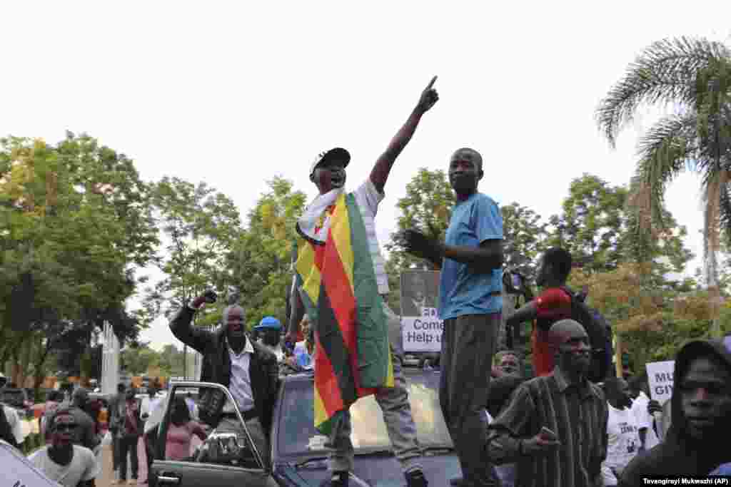 Zimbabueanos celebram nas ruas à porta do parlamento após o anúncio da resignação de Robert Mugabe