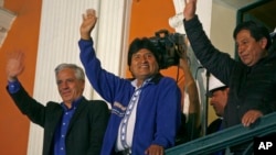 Presiden Bolivia Evo Morales (tengah) menyapa pendukungnya dari balkon istana presiden di La Paz, Bolivia, Minggu (12/10). (AP/Enric Marti)