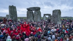 People celebrate the Winter Solstice sunrise celebrations at Stonehenge, England, Dec. 21, 2024. 