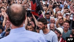 Kosovo's Albanians protest outside the parliament building in Pristina, Sept. 1, 2016. The protesters cheered as as the government withdrew a controversial draft law on a border demarcation agreement with Montenegro.