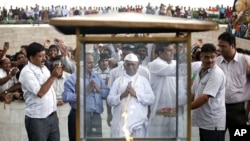 Veteran Indian social activist Anna Hazare (C) prays at the Mahatma Gandhi memorial at Rajghat in New Delhi August 19, 2011.