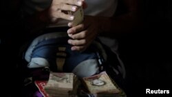 A man counts his money to place horse racing bets at a small warehouse on the outskirts of Caracas, Venezuela, October 7, 2017. 